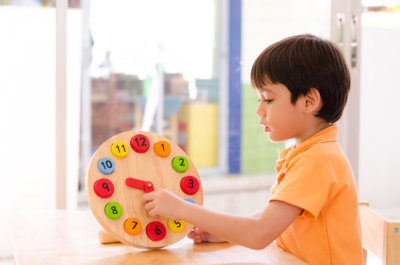 Little boy learning time with clock toy